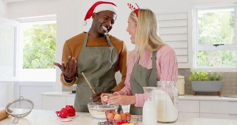 Diverse couple baking together in festive attire