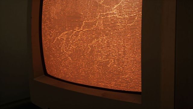 Glowing amber static on curved vintage crt monitor screen for retro tech design