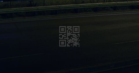 Illuminated pink qr code on dark urban street