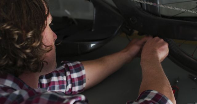 Young man repairing bicycle tire in a workshop - Download Free Stock Images Pikwizard.com