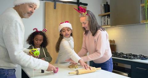 Multigenerational diverse family baking christmas cookies together in modern kitchen