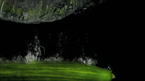Fresh Cucumber Splashing Into Water Against Black Background