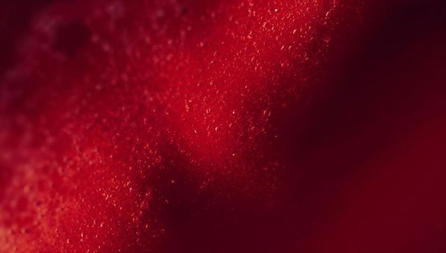 Luminous textured red surface with bead-like droplets