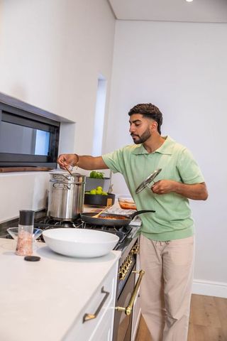 Man cooking with stainless steel pot in modern kitchen