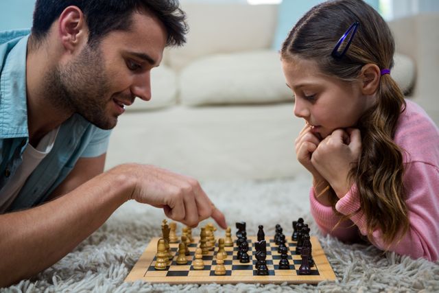 Father and daughter engaging in a game of chess on a cozy carpet in the living room. Ideal for illustrating family bonding, educational activities, and indoor leisure time. Perfect for use in parenting blogs, educational materials, and family-oriented advertisements.