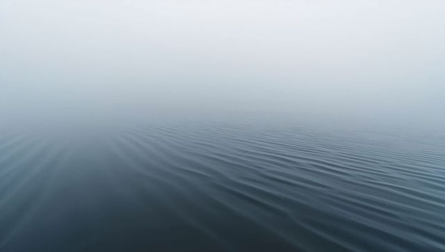 Hazy horizon ripples over calm blue-gray sea minimalist seascape
