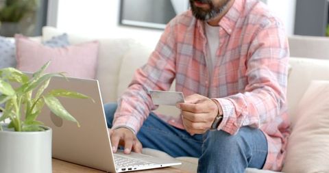 Man shopping online with credit card on laptop