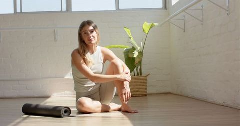 Woman Resting Next to Yoga Mat in Sunshine-Lit Studio - Download Free Stock Images Pikwizard.com