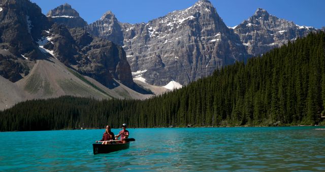 Couple Canoeing on Tranquil Lake with Mountain Backdrop - Download Free Stock Photos Pikwizard.com
