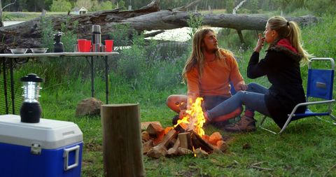 Couple Enjoying Marshmallow Roast Around Campfire