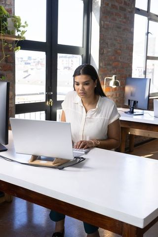 Professional Woman in Modern Loft Office Working on Laptop