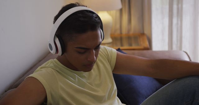 Teen Sitting on Couch Listening to Music with Headphones - Download Free Stock Images Pikwizard.com