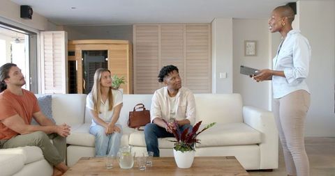 Diverse group engaged in tablet presentation in modern living room