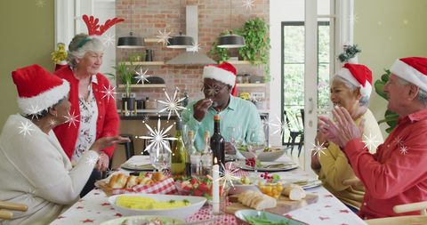Senior Friends Celebrating Christmas with Festive Meal and Santa Hats