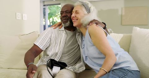 Senior Couple Embracing Happily on Cozy Couch at Home