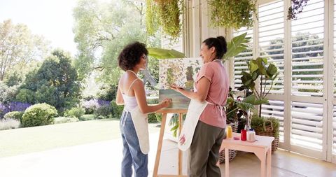 Mother and Daughter Enjoying Creative Painting Session Surrounded by Plants