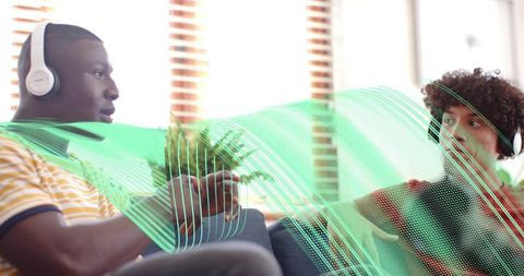 Friends chatting on couch wearing headphones with green digital audio wave overlay