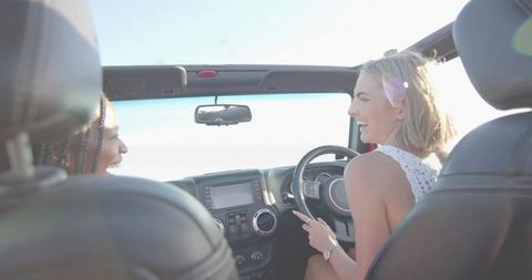 Women enjoying road trip in convertible car