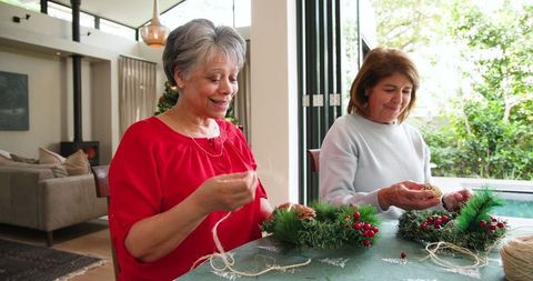 Mother and daughter crafting holiday wreaths together