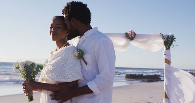 African american couple in love getting married, embracing and smiling on the beach. marriage, love and romance, holiday by the sea.
