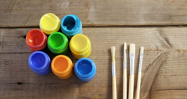 Multicolored Paint Pots and Brushes on Wooden Table - Download Free Stock Images Pikwizard.com