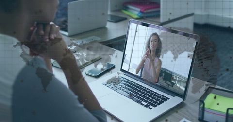 Woman Engaged in Virtual Meeting on Laptop in Office Environment