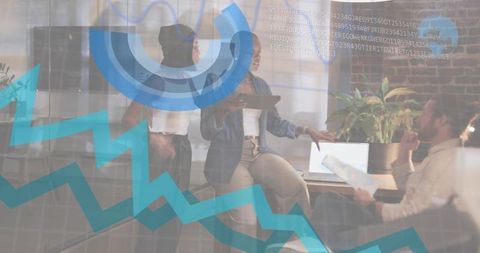 Team collaborating over data presentation using tablet and laptop in modern coworking office