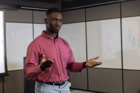 Confident professional presenting bar charts during meeting