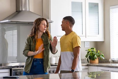 Young couple discussing and gesturing at modern kitchen island
