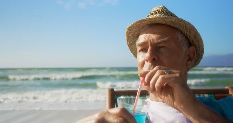Senior Man Relaxing with Cocktail on Sunny Beach Vacation