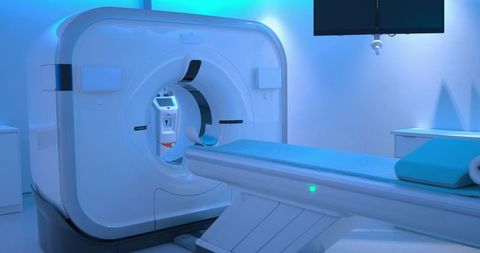 Modern mri ct scanner in radiology suite with patient table and blue ambient lighting