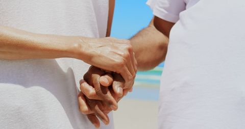Senior Couple Holding Hands on Sunny Beach