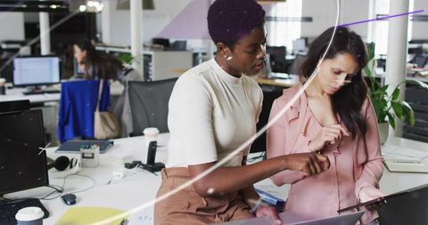 Diverse Coworkers Discussing Tablet in Open-Plan Office