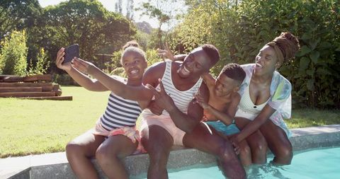 Happy Family Taking Selfie by Pool on Sunny Day