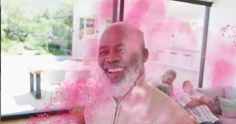 Joyful Man Celebrating at Home with Vibrant Pink Powder