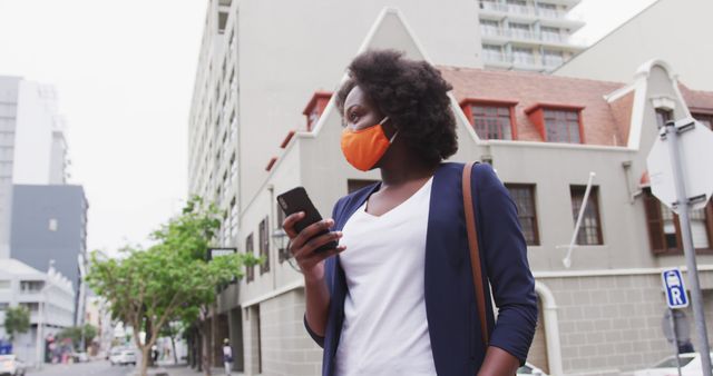 Businesswoman Wearing Orange Face Mask Using Smartphone in Urban Area - Download Free Stock Images Pikwizard.com