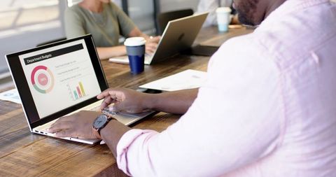 Diverse Business Team Reviewing Budget Presentation on Laptop