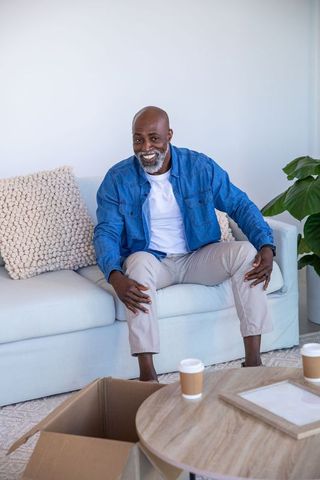 Smiling Mature Man Relaxing on Sofa with Coffee in Cozy Living Room
