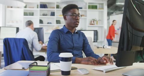 Focused professional working on computer in modern office
