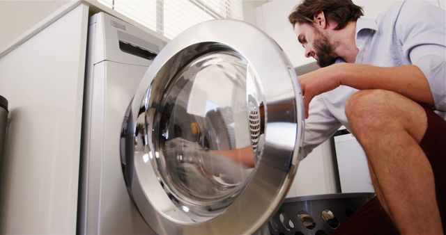 Man Using Washing Machine in Modern Laundry Room - Download Free Stock Images Pikwizard.com