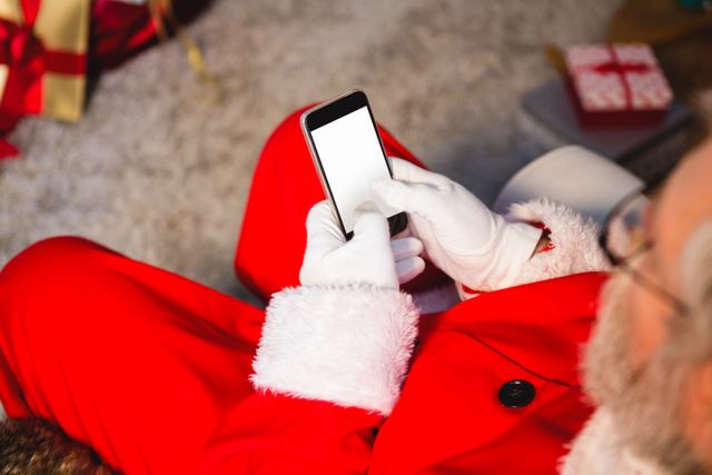 Top-view of santa claus using mobile phone at home