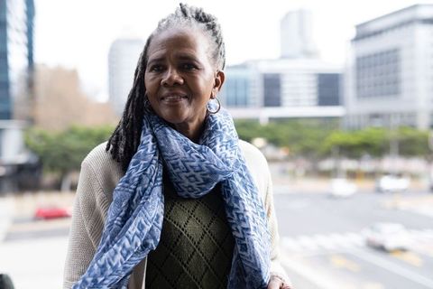 Senior african-american woman wearing blue scarf and cardigan in urban street portrait