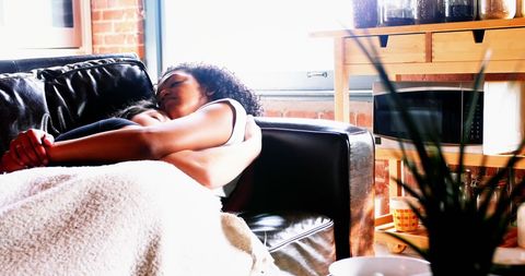 Lesbian couple sleeping on cozy couch at home