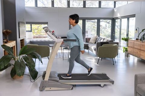 Active Woman Walking on Treadmill in Modern Living Room