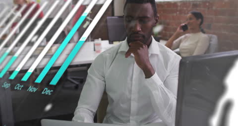 Businessman is focused on computer with overlaid digital graphic representing financial data processing. Ideal for projects related to modern business, finance technology presentation, and corporate innovation marketing. Highlights synergy between human decision-making process and digital automation.