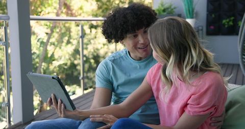 Young couple video chatting outdoors on digital tablet