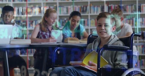 Smiling boy in wheelchair reading yellow book in library with diverse classmates studying