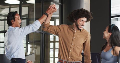 Happy Diverse Team Celebrating Success in Modern Office Environment