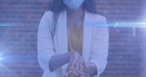 Woman practicing hand hygiene with sanitizer in office