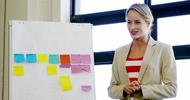 Smiling Businesswoman Leading Office Presentation with Sticky Notes - Download Free Stock Images Pikwizard.com